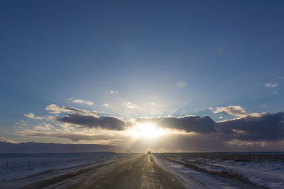 Road by sea against sky during sunset