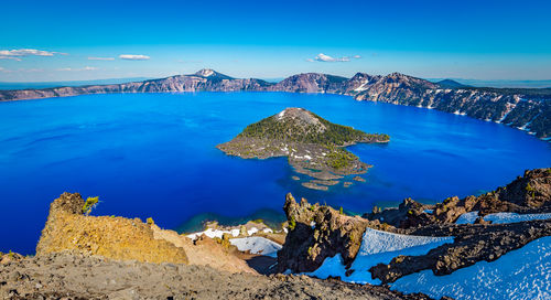 Panoramic view of sea and mountain against blue sky