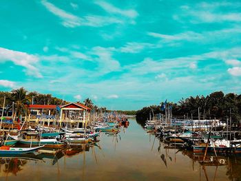 Boats moored in harbor against sky