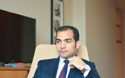 Close-up of serious man looking away while sitting