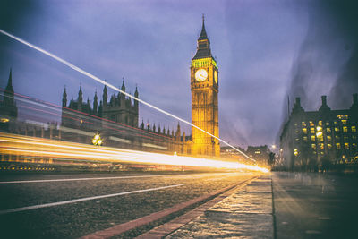 Light trails in city against sky at night