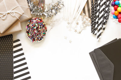 High angle view of confetti with candles and gifts and gumballs on marble