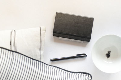 Directly above shot of pen and books with pillows on table
