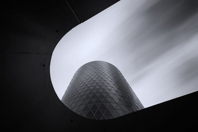 Low angle view of modern building against cloudy sky