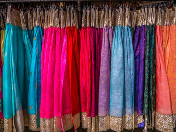 Full frame shot of multi colored womenswear hanging on rack in store