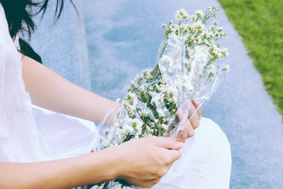 Midsection of woman holding bouquet