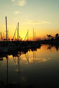 Silhouette sailboats in lake against sky during sunset