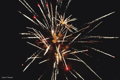 Low angle view of firework display at night