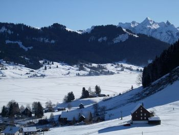 Snow covered landscape against clear sky