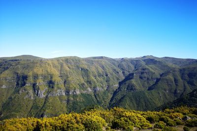 Scenic view of mountains against clear blue sky