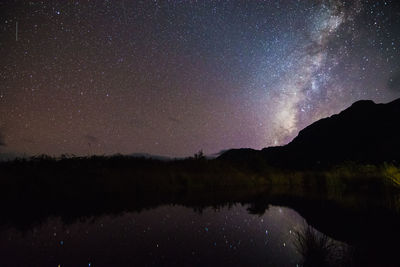 Scenic view of lake against sky at night