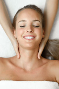 Cropped hands of masseur giving massage to woman at spa