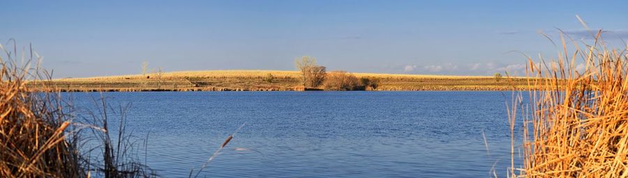 Panoramic view of lake against clear blue sky