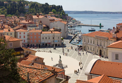 High angle view of townscape by sea against sky