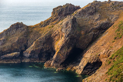 Rock formations by sea against sky