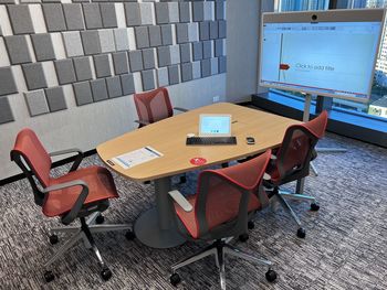 High angle view of empty chairs and table against wall