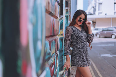 Young woman standing on mobile phone in city