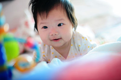 Close-up of cute baby boy on bed