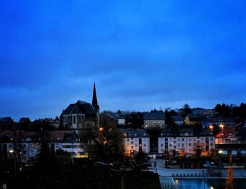 Buildings in city against blue sky