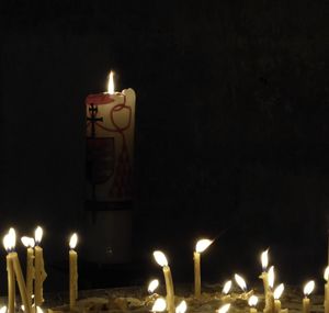 Lit candle in dark room