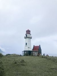 Lighthouse by sea against sky