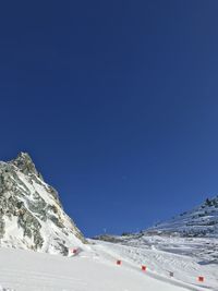 Snow covered mountain against clear blue sky