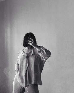 Young woman standing against wall