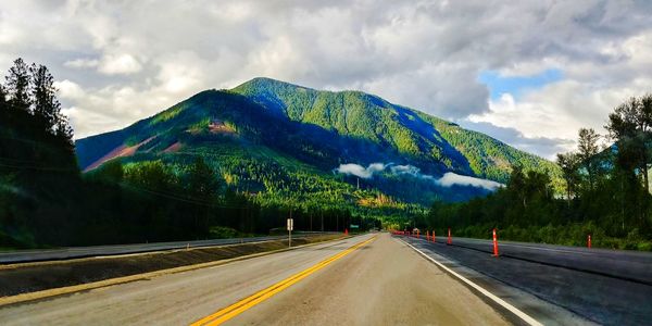 Road by mountain against sky