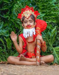 Full length of cute girl sitting outdoors