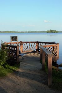 Pier over lake against blue sky