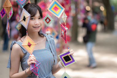 Portrait of young woman standing in city
