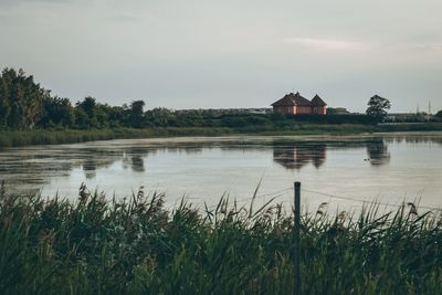 Scenic view of lake by building against sky