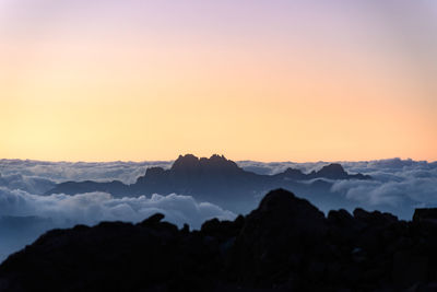 Scenic view of silhouette mountains against sky at sunset