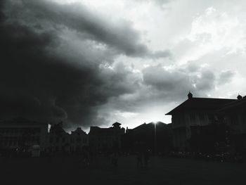 Silhouette buildings against cloudy sky