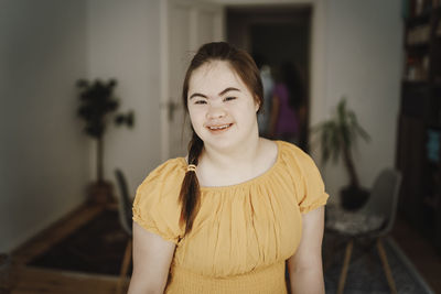 Portrait of smiling woman with down syndrome at home