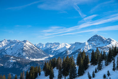 Scenic view of snowcapped mountains against blue sky