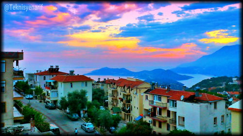 Buildings in town against cloudy sky