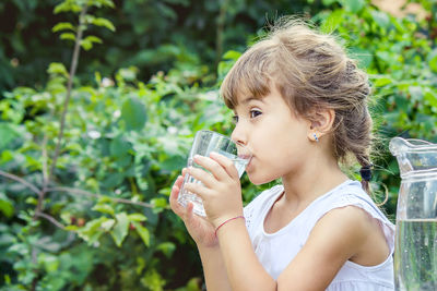 Young woman drinking water in park