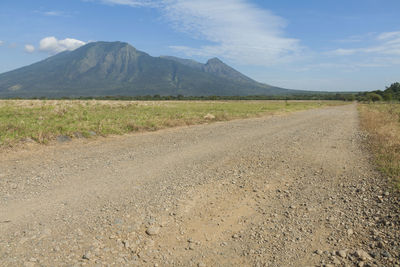 Scenic view of road by land against sky