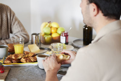 Man holding sandwich during breakfast