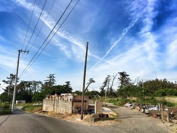 Electricity pylon against cloudy sky