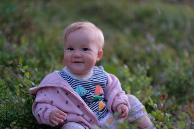 Portrait of cute smiling baby holding plant
