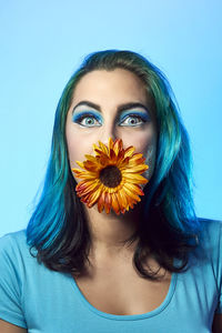 Portrait of beautiful young woman against blue background