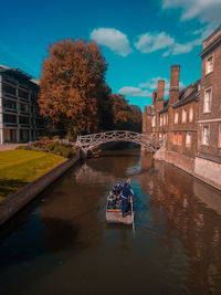 Scenic view of river amidst buildings against sky