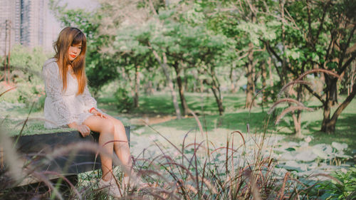 Portrait of woman sitting by plants