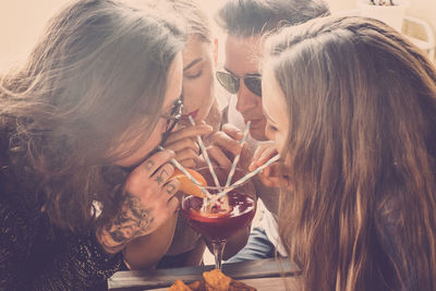 Friends drinking drink from wineglass at restaurant