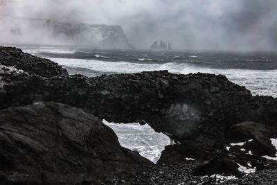 Rocks on beach against sky