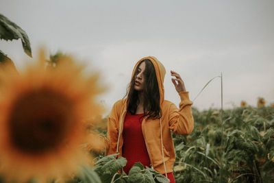 Young woman standing at sunflower farm