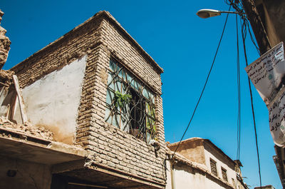 Low angle view of old building against blue sky