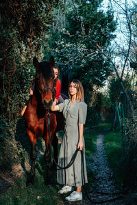 Woman with dog by trees in park